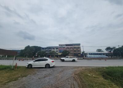 Street view of commercial buildings with parked vehicles.