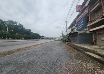 Commercial buildings along a road with cloudy sky