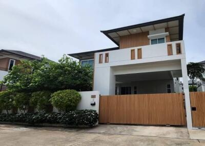 modern two-story house with a fenced yard