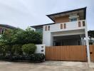 modern two-story house with a fenced yard