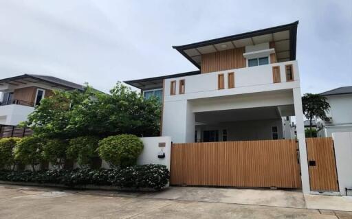 modern two-story house with a fenced yard