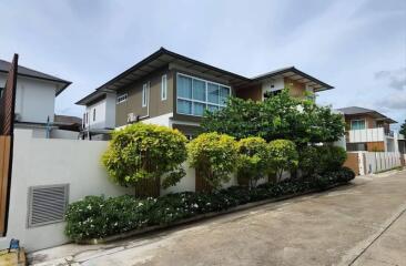 Modern two-story house with lush greenery