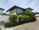 Modern two-story house with lush greenery