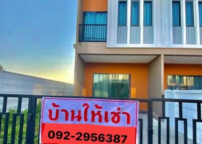 A modern two-story house with a sign for rent placed on the front gate.