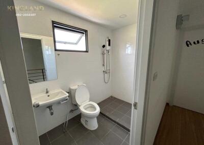 Modern bathroom with toilet, sink, and shower