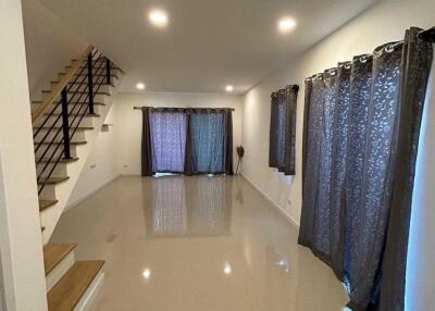 Living area with staircase and large windows