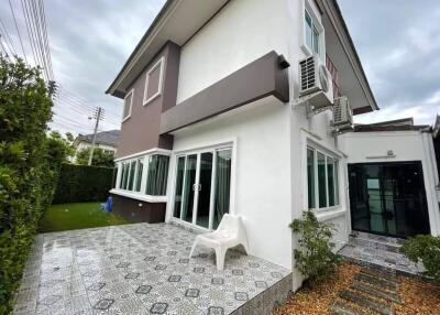 Exterior view of a modern two-story house with a tiled patio