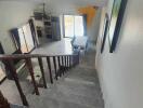 View of living area with dining table and kitchen from staircase