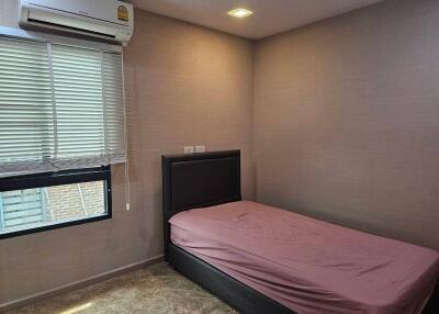 Modest bedroom with single bed and air conditioning unit