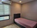 Modest bedroom with single bed and air conditioning unit