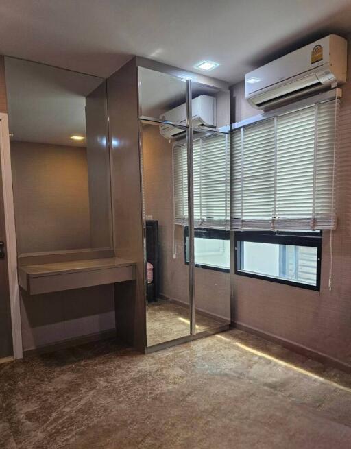 Bedroom with mirrored closet and air conditioner