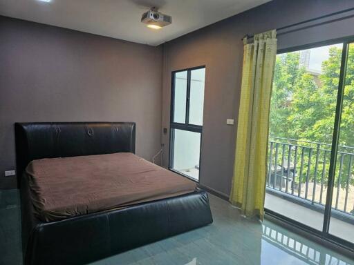 Spacious bedroom with a large window and balcony access