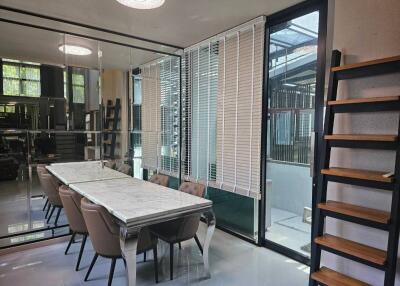 Modern dining area with large windows, blinds, and an elegant dining table