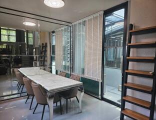 Modern dining area with large windows, blinds, and an elegant dining table