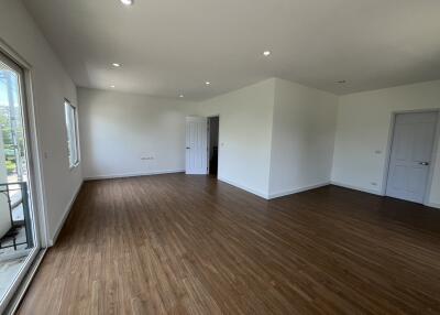 Spacious living room with wood flooring and natural light