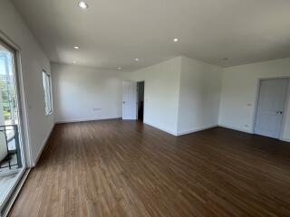 Spacious living room with wood flooring and natural light