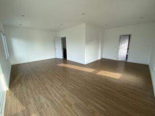 Spacious living room with wooden flooring and ample natural light