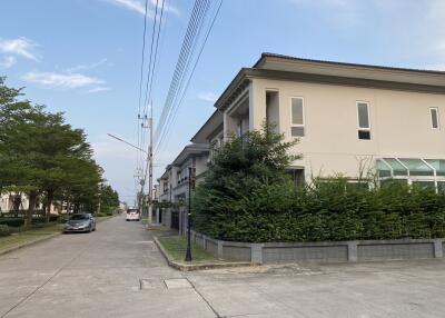 Exterior view of residential building with surrounding greenery and street