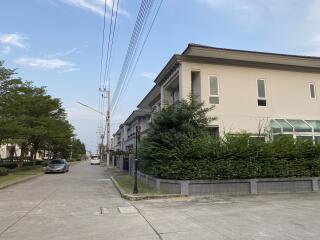 Exterior view of residential building with surrounding greenery and street