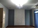 Bedroom with chandelier and patterned wallpaper