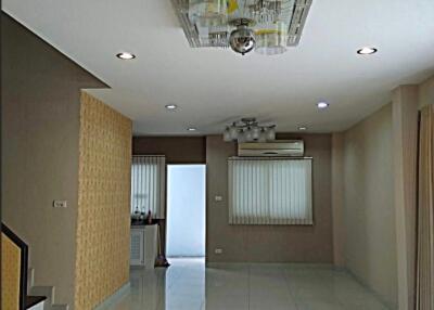 Living room with modern ceiling light, tiled floor, and stairs