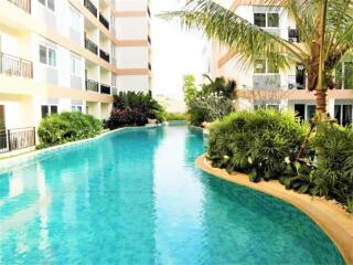 View of modern apartment buildings with swimming pool and lush landscaping