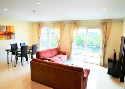 Living room with seating area, dining table, and large windows