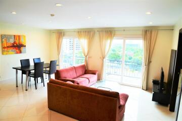 Living room with seating area, dining table, and large windows