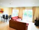 Living room with seating area, dining table, and large windows