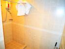 Well-lit tiled shower area with water heater