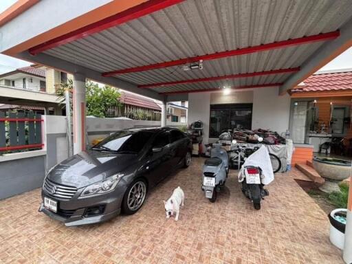 Covered carport with car and motorcycles