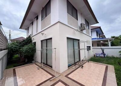 Exterior view of a two-story house with outdoor tiled patio