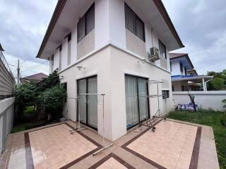 Exterior view of a two-story house with outdoor tiled patio