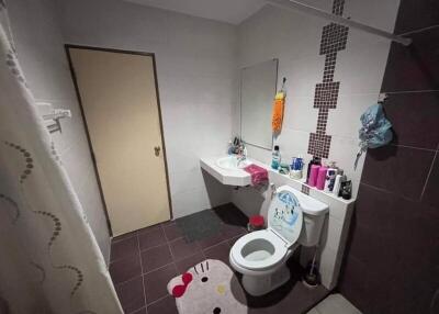 Bathroom with white fixtures, a mirror, and a variety of toiletries