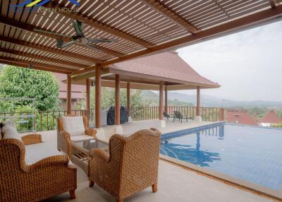 Outdoor seating area with pool and scenic view