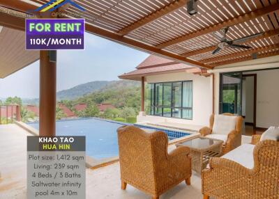 Covered patio with wicker furniture overlooking pool and scenic view