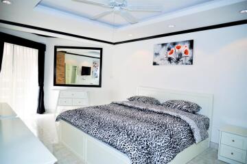 Modern bedroom with patterned bedding and a large mirror