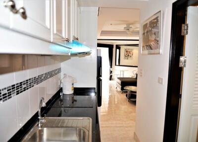 Compact kitchen with modern amenities leading to a living area