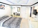 Modernly decorated bedroom with a large bed and mirrored wardrobe