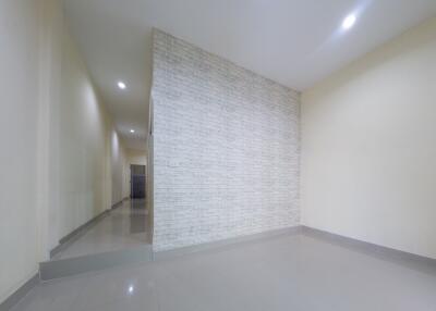 Empty room with tiled floor and brick accent wall