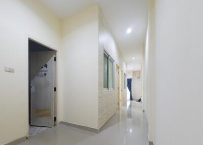 Spacious hallway with glossy floor tiles and soft lighting