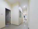 Spacious hallway with glossy floor tiles and soft lighting