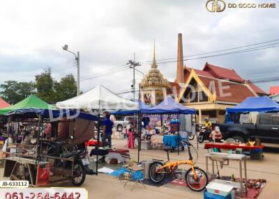 Outdoor market scene with tents, bikes, and a temple in the background