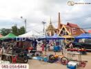 Outdoor market scene with tents, bikes, and a temple in the background