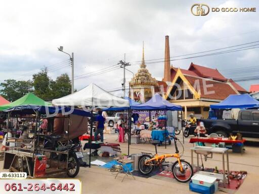 Outdoor market scene with tents, bikes, and a temple in the background