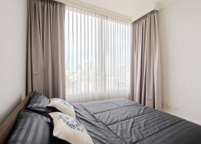 Modern bedroom with large window and sleek furnishings