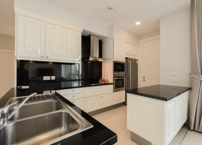 Modern kitchen with white cabinetry and black countertops