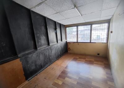 Empty room with ceiling tiles and large windows