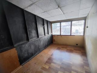 Empty room with ceiling tiles and large windows