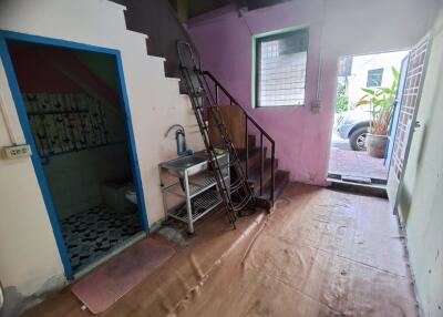 Entryway with ladder, sink, window and open door showing outside view